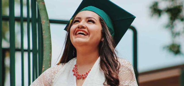 Woman with graduation cap looking at the sky